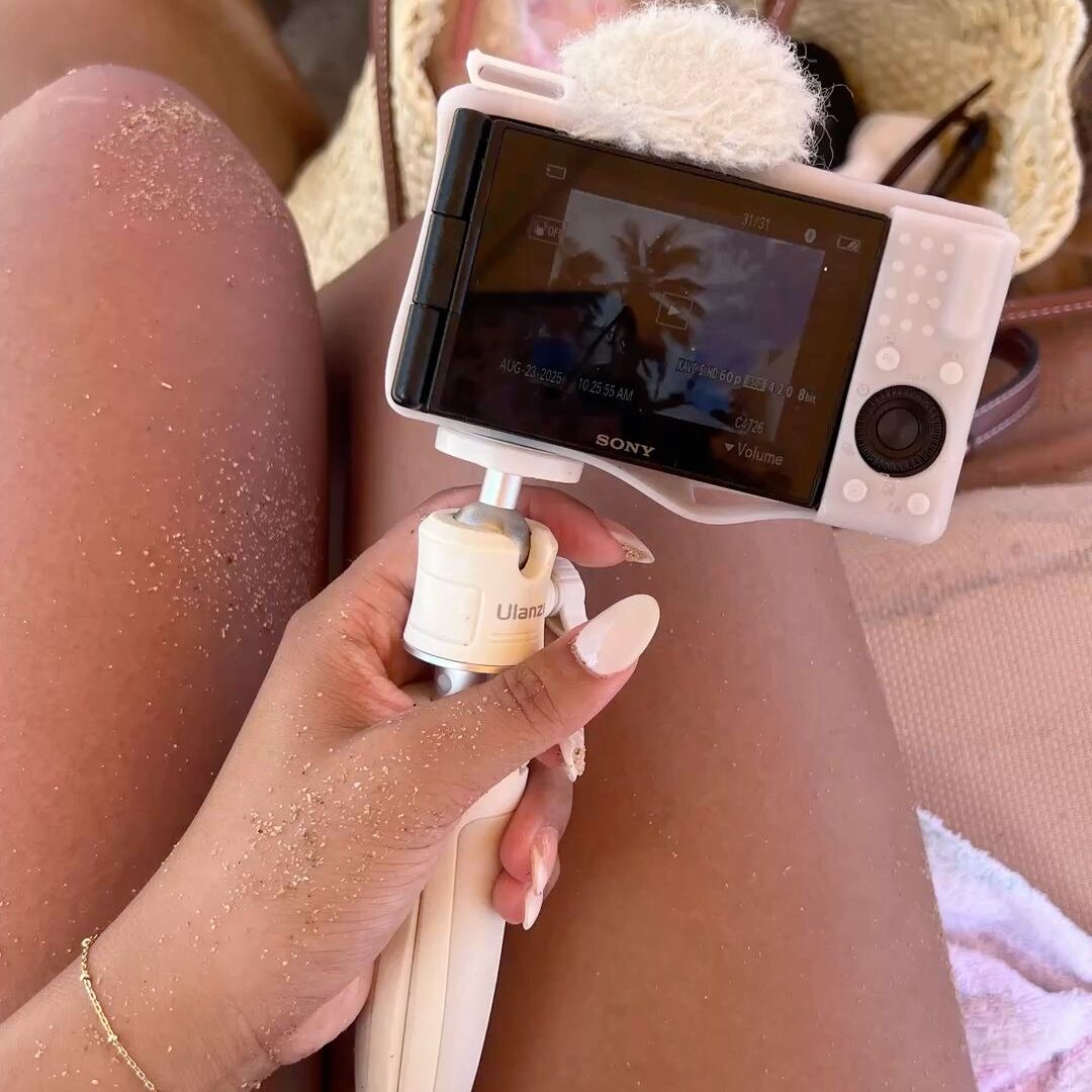 Gros plan sur une main tenant une caméra de vlog pour capturer du contenu de vacances