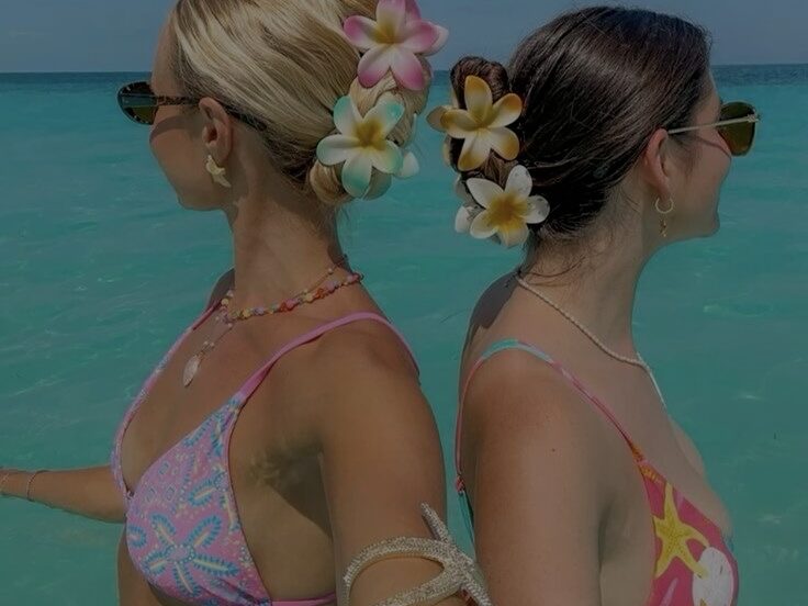 Deux jeunes femmes de dos dans une eau de mer turquoise, portant des Baekini.